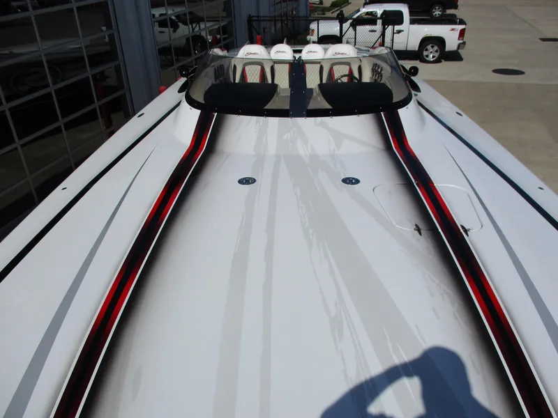 Slide: The Image of 2012 Skater 482 speedboat with sleek design and red accents, parked near a white truck. - 9