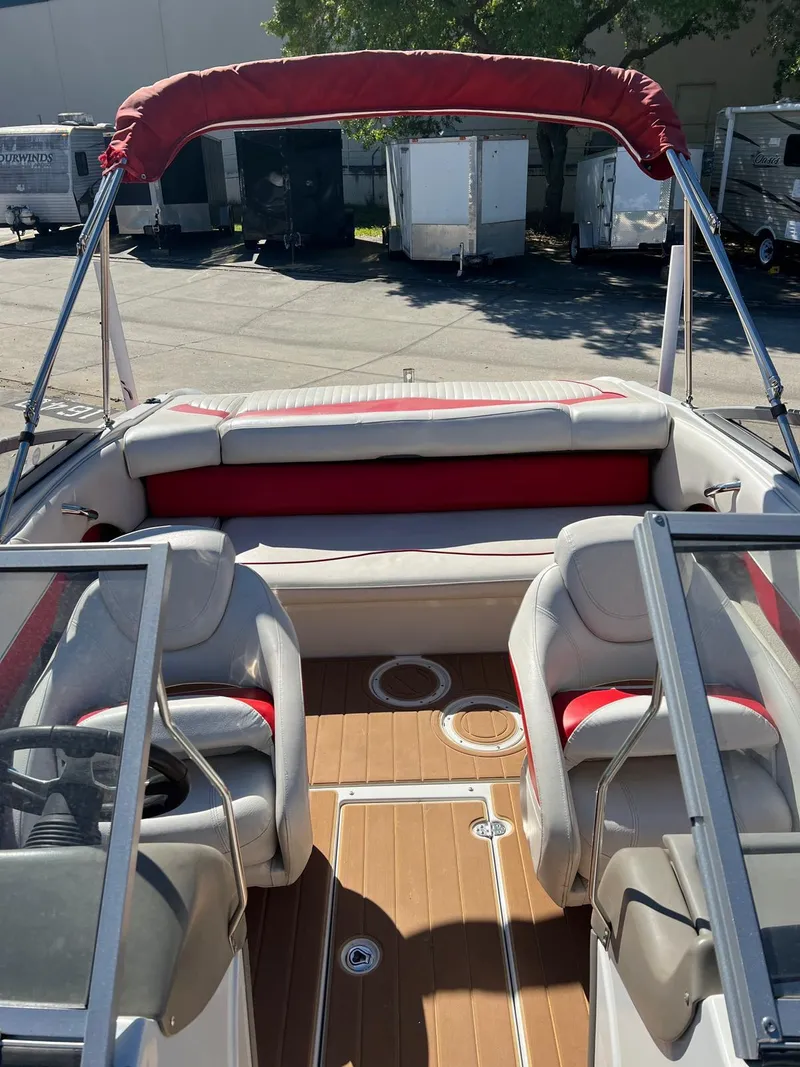 Slide: The Image of 2010 Crownline 195SS boat interior with red and white seating, open deck, and canopy. - 17