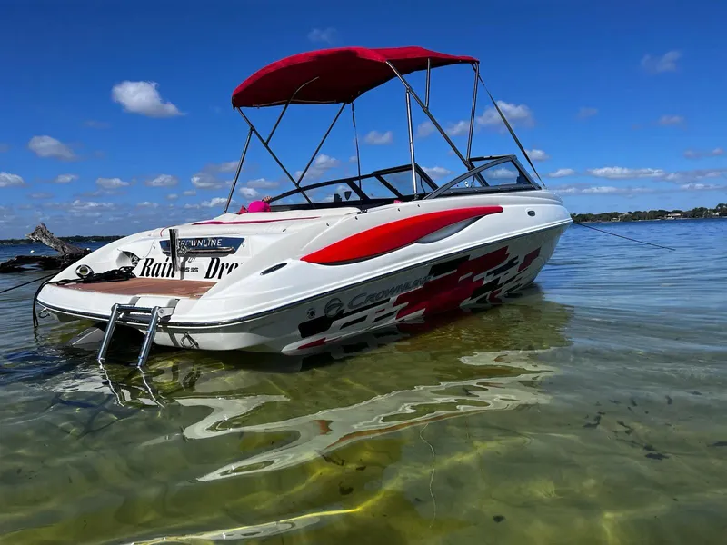 Slide: The Image of 2010 Crownline 195SS boat with red canopy on clear water under blue sky. - 6