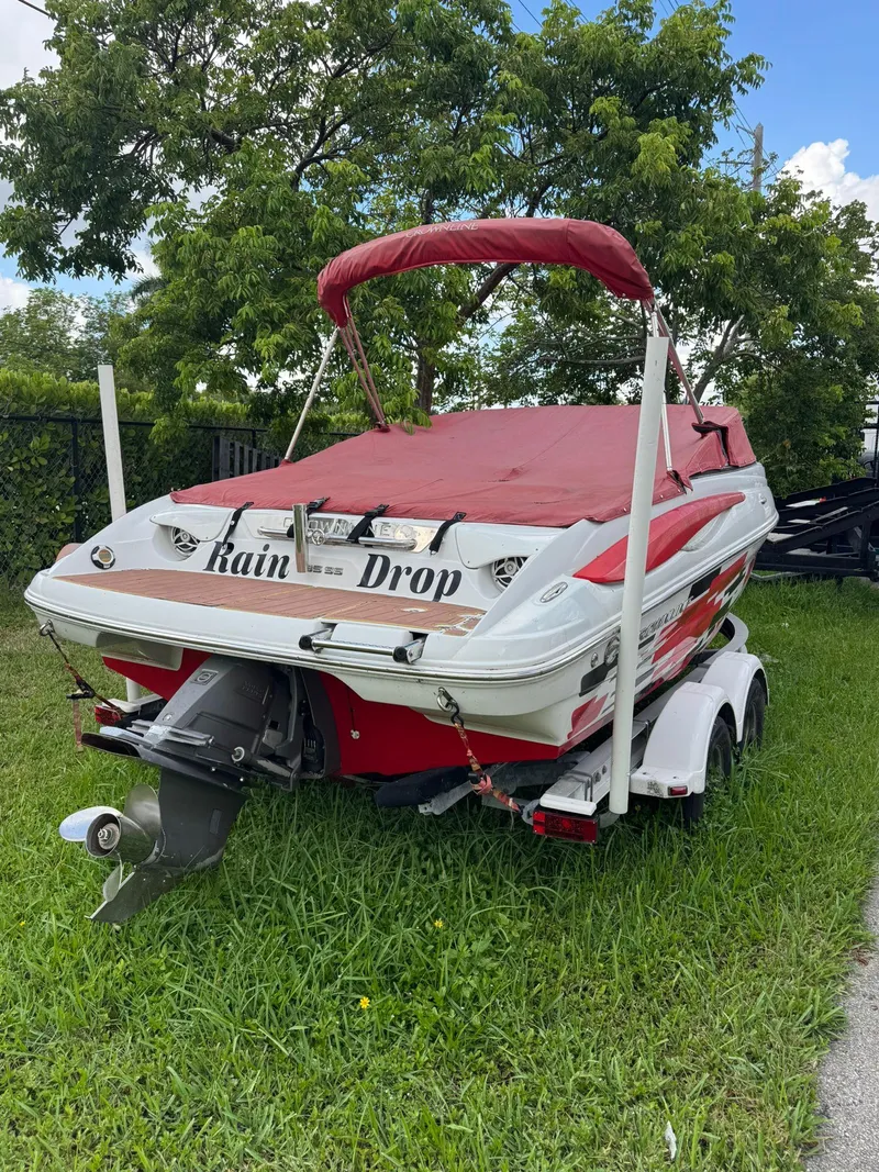 Slide: The Image of 2010 Crownline 195SS boat with red cover on trailer, parked on grass. - 9