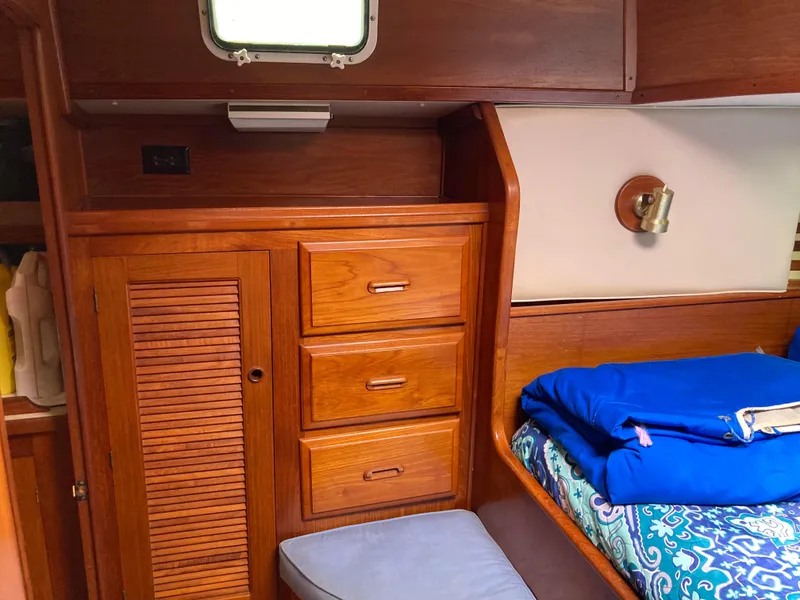 Slide: The Image of 1985 Endeavour 40 Center Cockpit interior with wooden cabinetry and cozy bedding. - 14