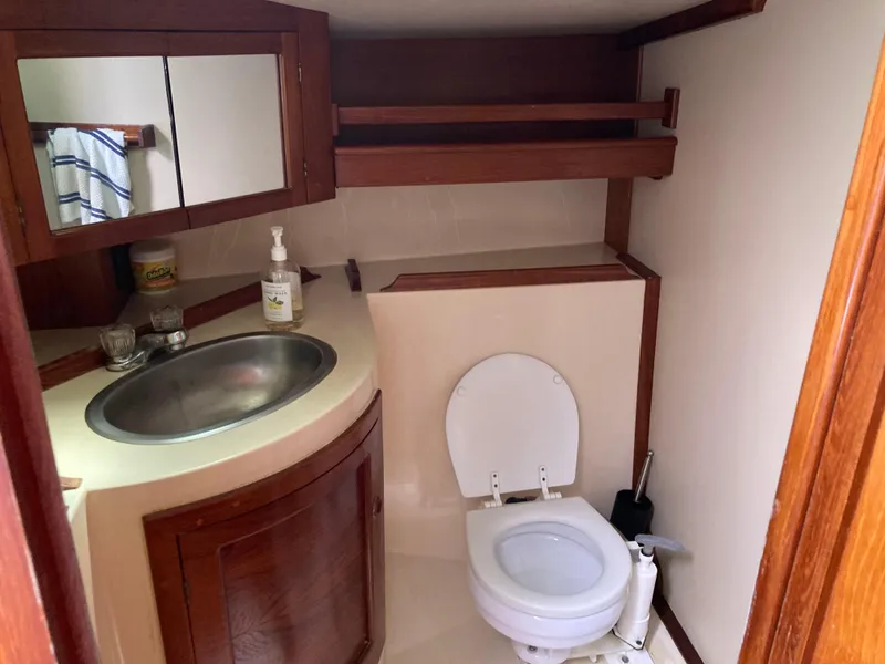 Slide: The Image of 1985 Endeavour 40 Center Cockpit bathroom with sink, mirror, and toilet. - 15