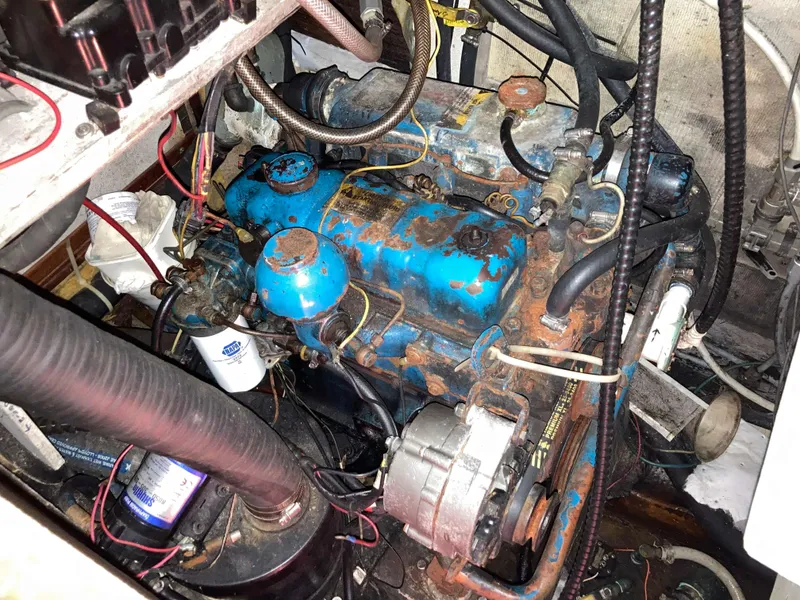 Slide: The Image of Engine compartment of 1985 Endeavour 40 Center Cockpit sailboat, showing blue engine and wiring. - 17