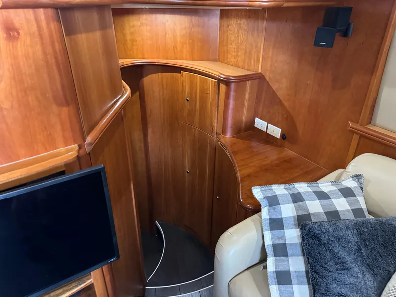 Slide: The Image of 2001 Silverton 410 Sport Bridge interior with wood paneling and cozy seating area. - 11