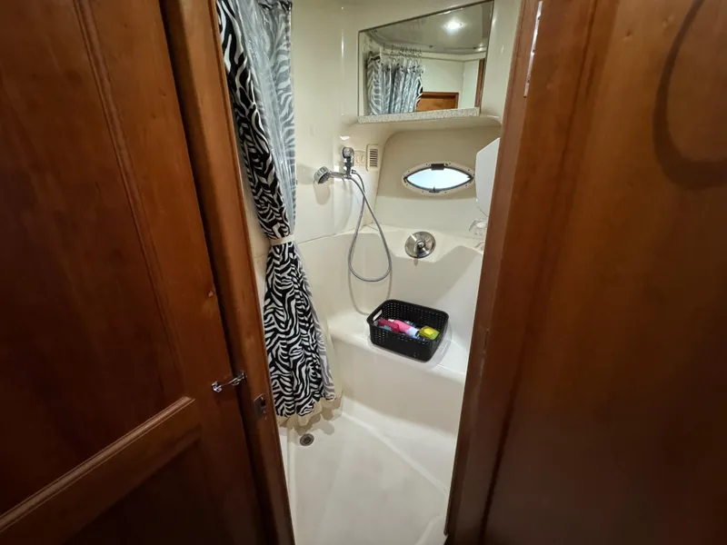 Slide: The Image of 2001 Silverton 410 Sport Bridge bathroom with shower, zebra curtain, and wooden door. - 14