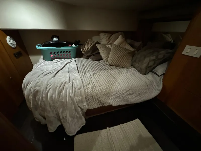 Slide: The Image of Cozy bedroom in 2001 Silverton 410 Sport Bridge with pillows and laundry basket. - 19