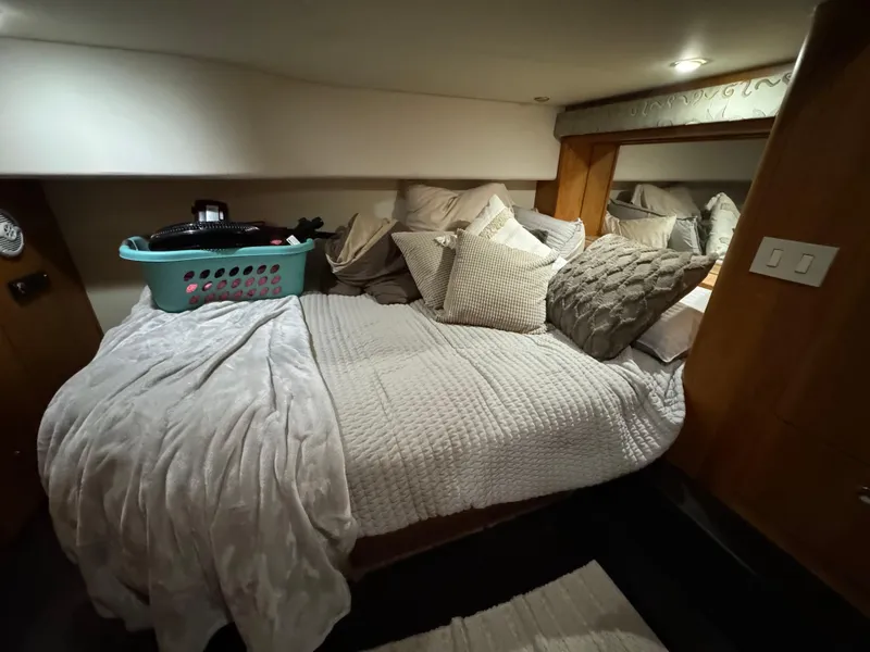 Slide: The Image of Cozy bedroom in 2001 Silverton 410 Sport Bridge with plush bedding and laundry basket. - 20
