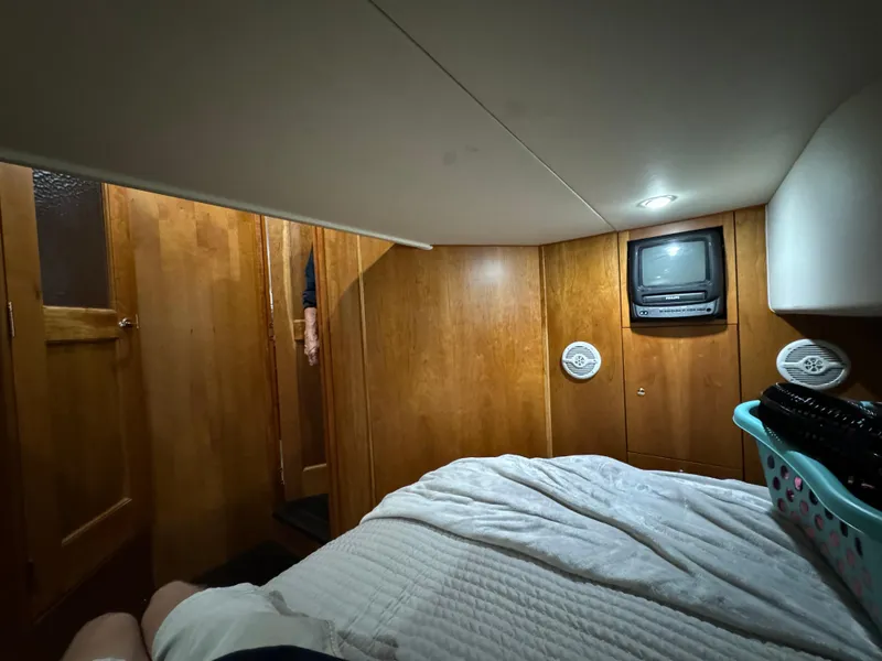 Slide: The Image of Cozy cabin interior of 2001 Silverton 410 Sport Bridge with TV and wood paneling. - 21