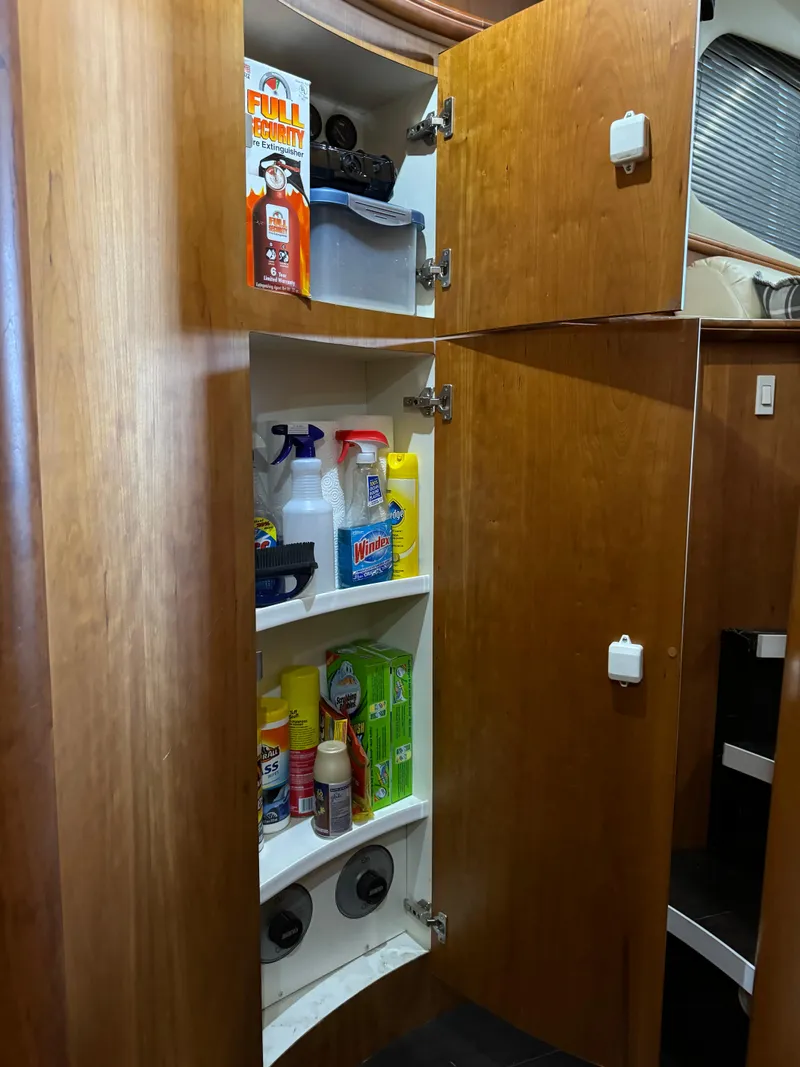 Slide: The Image of Wooden cabinet with cleaning supplies in a 2001 Silverton 410 Sport Bridge yacht. - 24