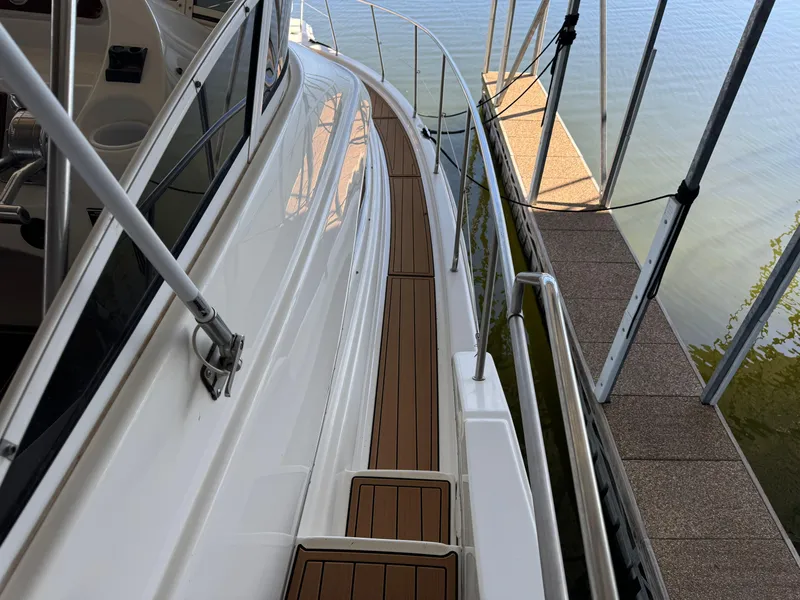 Slide: The Image of 2001 Silverton 410 Sport Bridge yacht docked, showcasing sleek deck design and railing. - 42