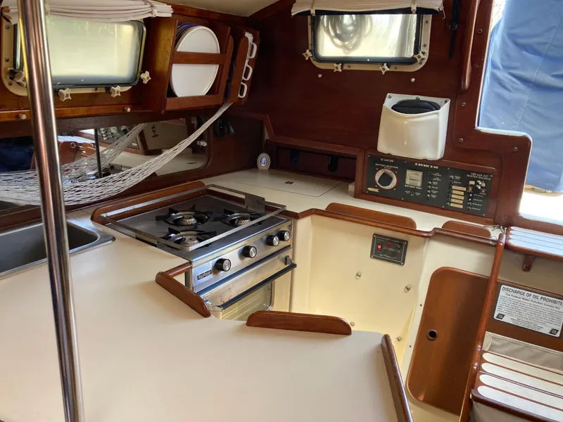 Slide: The Image of 1984 Irwin 34 Sloop interior kitchen with stove, sink, and wooden cabinetry. - 4
