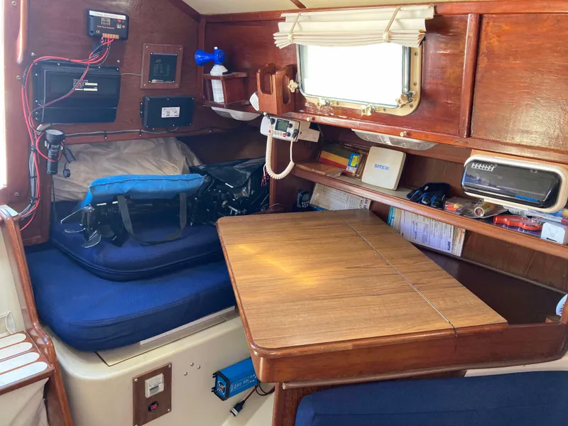 Slide: The Image of Cozy interior of 1984 Irwin 34 Sloop with wooden table and blue cushions. - 5