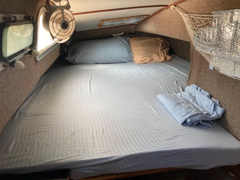 Slide: The Image of Cozy cabin interior of 1979 Catamaran Ocean Winds 33 with bed and fan. - 10