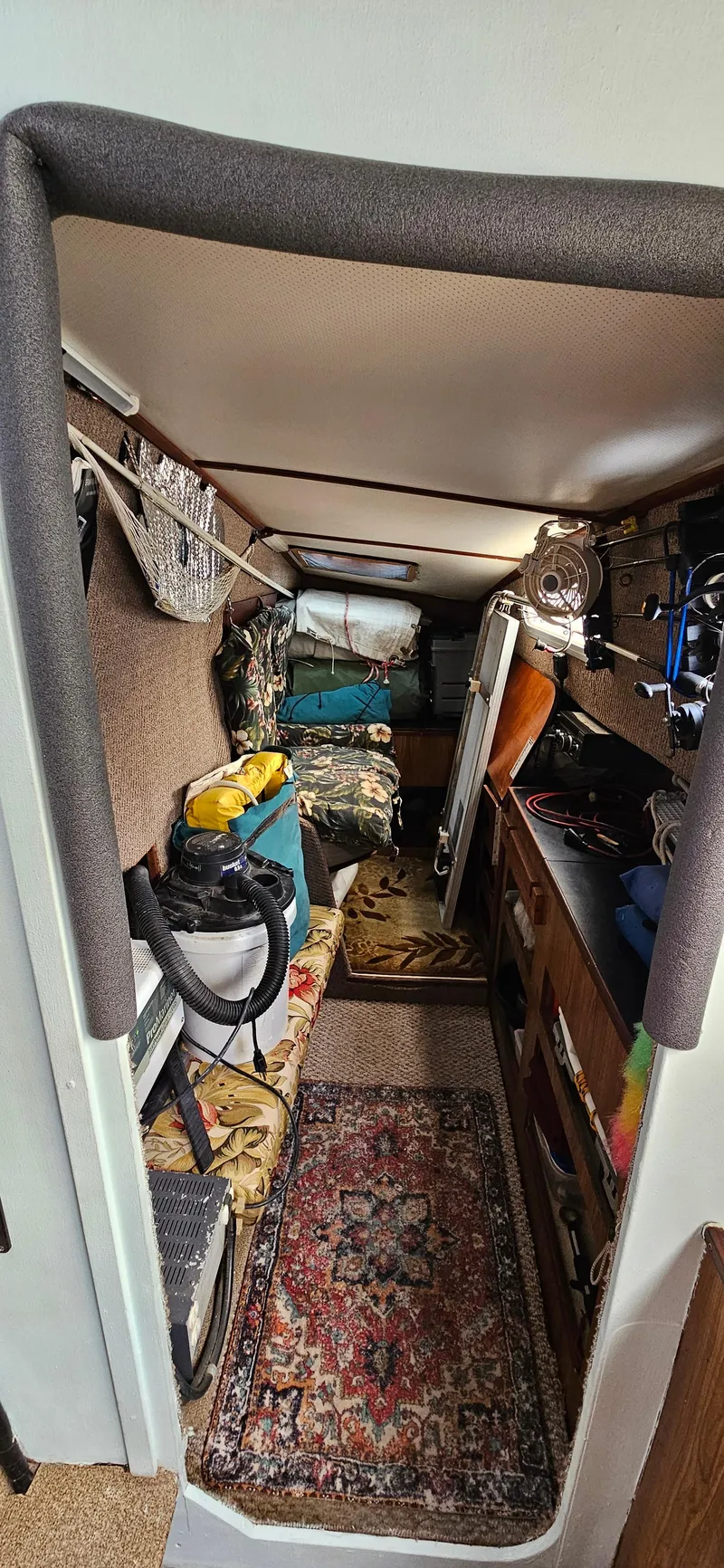 Slide: The Image of Interior of 1979 Catamaran Ocean Winds 33, featuring cozy cabin with storage and decor. - 11