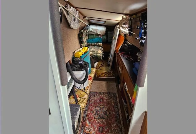 Slide: The Image of Interior of 1979 Catamaran Ocean Winds 33, featuring cozy cabin with storage and seating. - 12