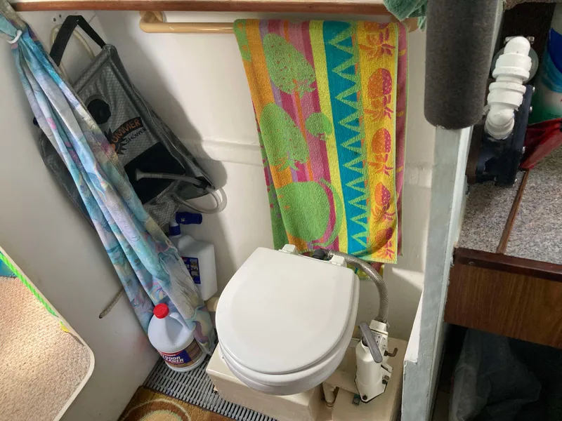 Slide: The Image of 1979 Catamaran Ocean Winds 33 bathroom with colorful towel and cleaning supplies. - 13
