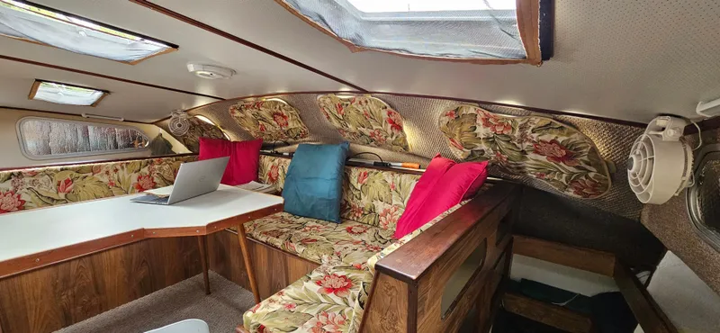 Slide: The Image of Interior of 1979 Catamaran Ocean Winds 33 with floral upholstery and colorful cushions. - 5