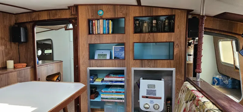 Slide: The Image of Interior of 1979 Catamaran Ocean Winds 33 with wooden shelves and nautical decor. - 6