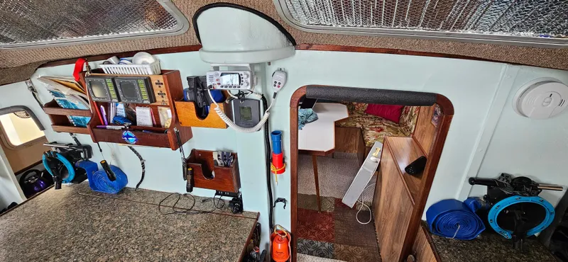 Slide: The Image of Interior of 1979 Catamaran Ocean Winds 33 with navigation equipment and cozy cabin space. - 7