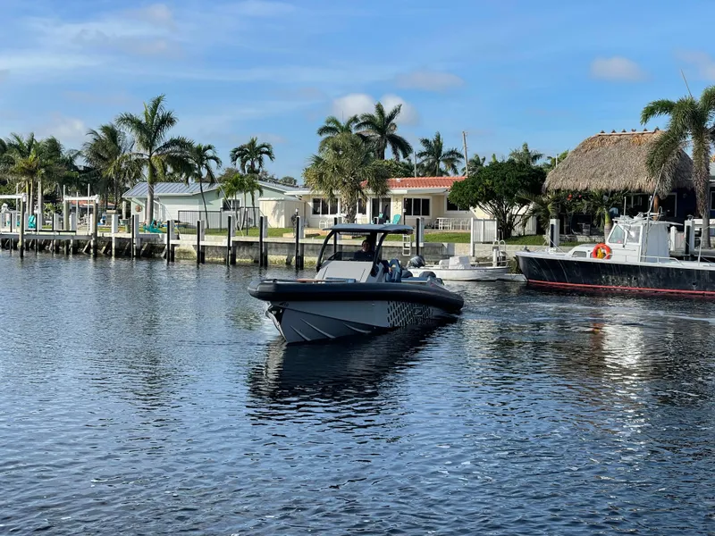 Slide: The Image of Skipper-BSK 38NC boat on a calm waterfront, 2023 model, with palm trees in the background. - 10