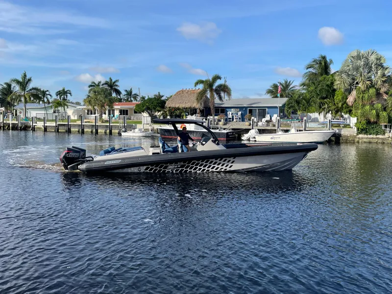 Slide: The Image of 2023 Skipper-BSK 38NC boat cruising on a sunny waterfront with palm trees. - 15