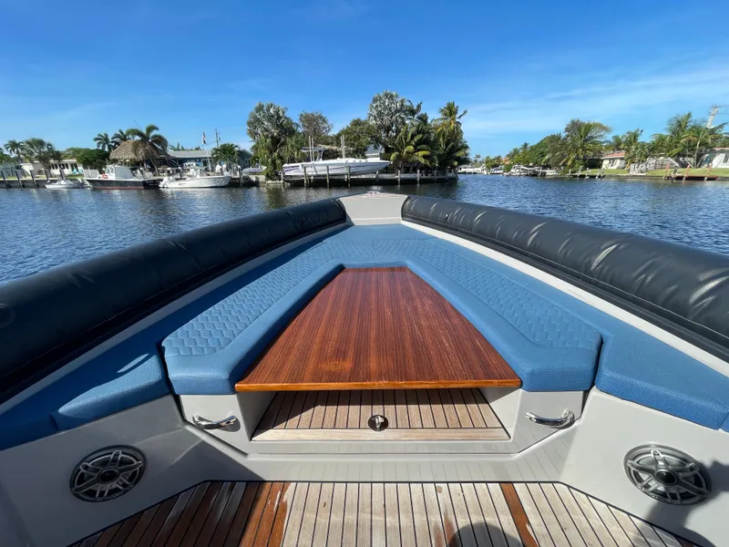Slide: The Image of 2023 Skipper-BSK 38NC boat with blue seating and wooden table on a sunny day. - 19