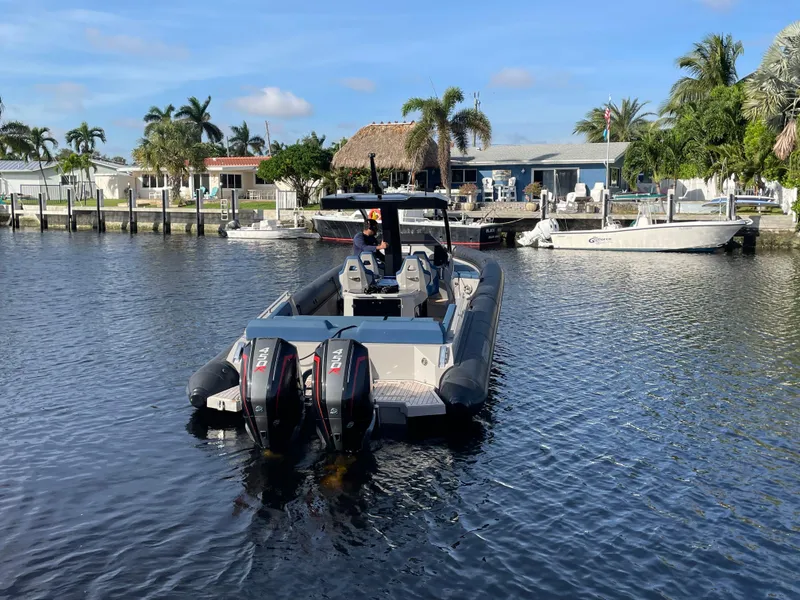 Slide: The Image of 2023 Skipper-BSK 38NC boat with dual engines on a sunny waterfront. - 2