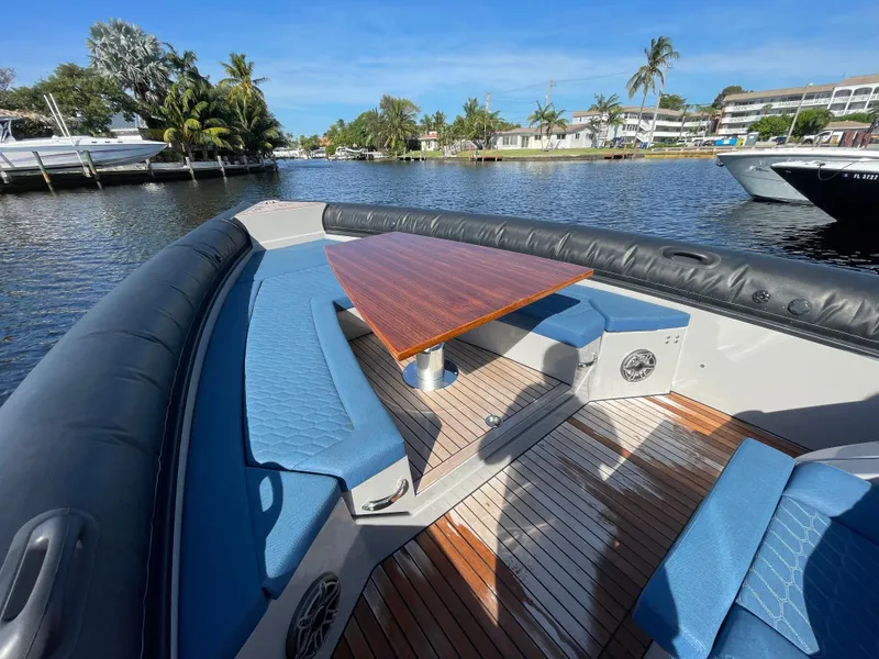 Slide: The Image of 2023 Skipper-BSK 38NC boat with blue seating and wooden deck on a sunny day. - 21