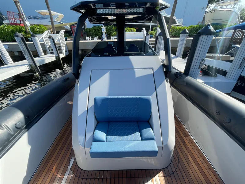 Slide: The Image of 2023 Skipper-BSK 38NC boat with blue seating and wooden deck at a marina. - 23