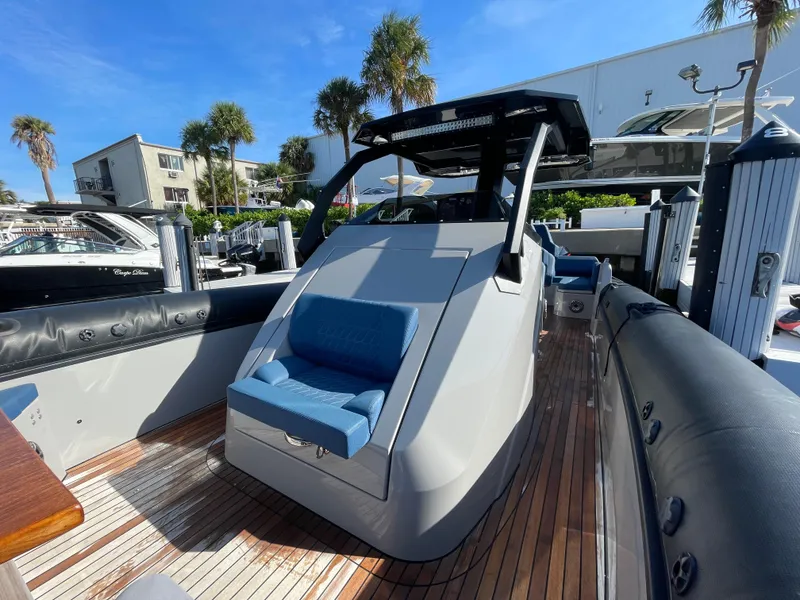 Slide: The Image of 2023 Skipper-BSK 38NC boat with sleek design and blue seating, docked under clear skies. - 25
