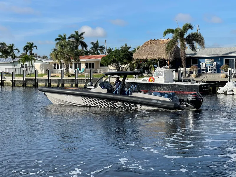 Slide: The Image of 2023 Skipper-BSK 38NC boat cruising on a sunny day near waterfront homes. - 6
