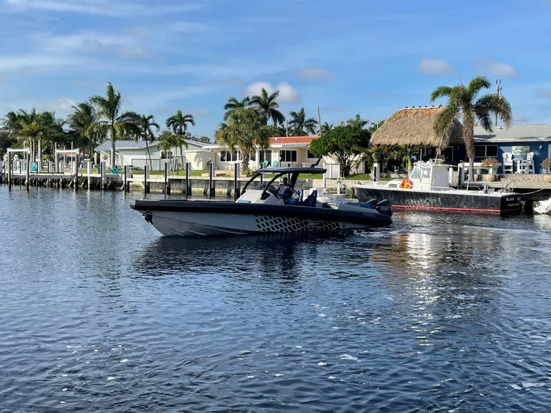 Slide: The Image of 2023 Skipper-BSK 38NC boat on a sunny waterfront with palm trees. - 8