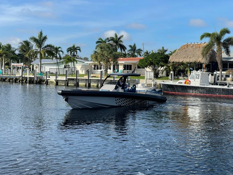 Slide: The Image of 2023 Skipper-BSK 38NC boat cruising on a sunny waterfront with palm trees. - 9