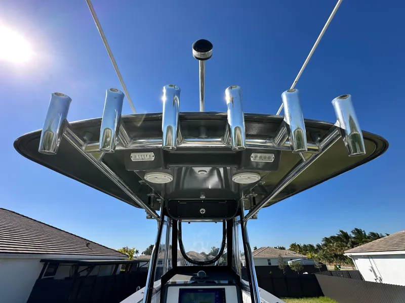 Slide: The Image of 2005 Contender 36 Open boat with rod holders and electronics, under clear blue sky. - 12