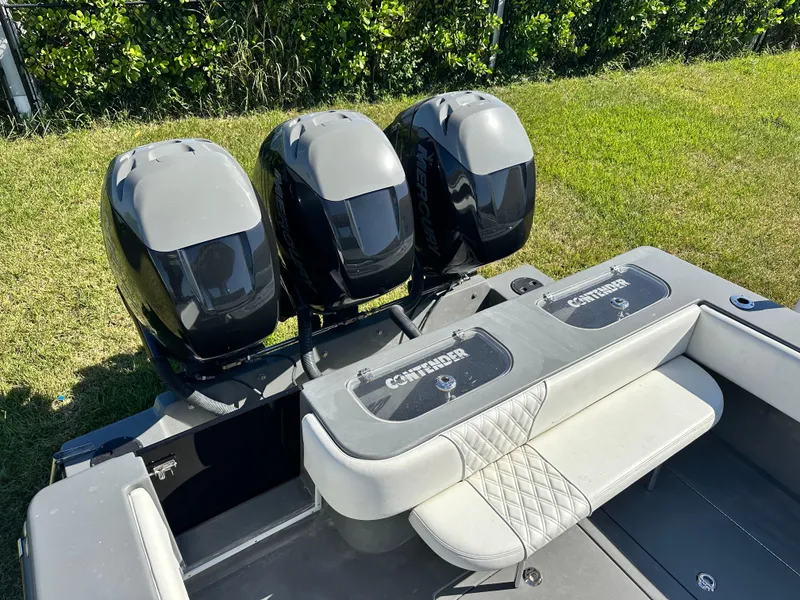 Slide: The Image of 2005 Contender 36 Open boat with triple outboard engines, rear seating, and lush green background. - 21