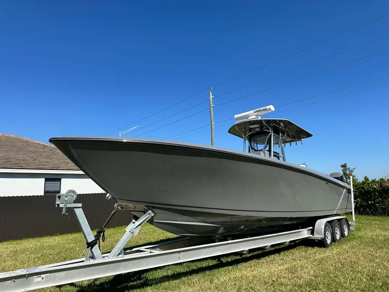 Slide: The Image of 2005 Contender 36 Open boat on trailer under clear blue sky. - 3