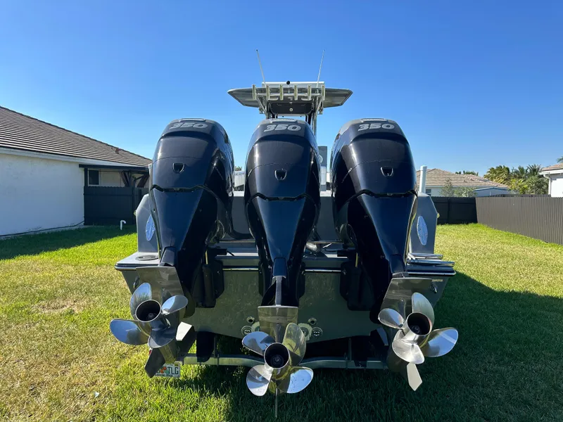 Slide: The Image of 2005 Contender 36 Open boat with triple 350 horsepower engines, parked on grass. - 6