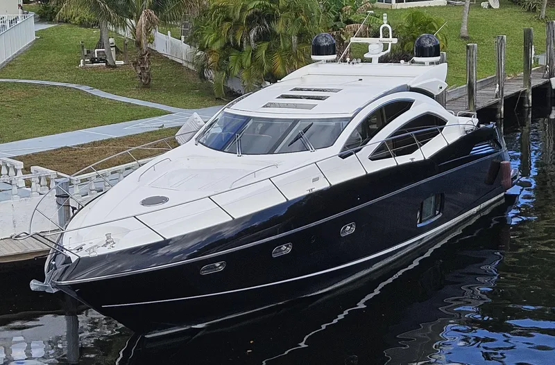 The Image of 2010 Sunseeker Predator 64 yacht docked by lush greenery. - 0