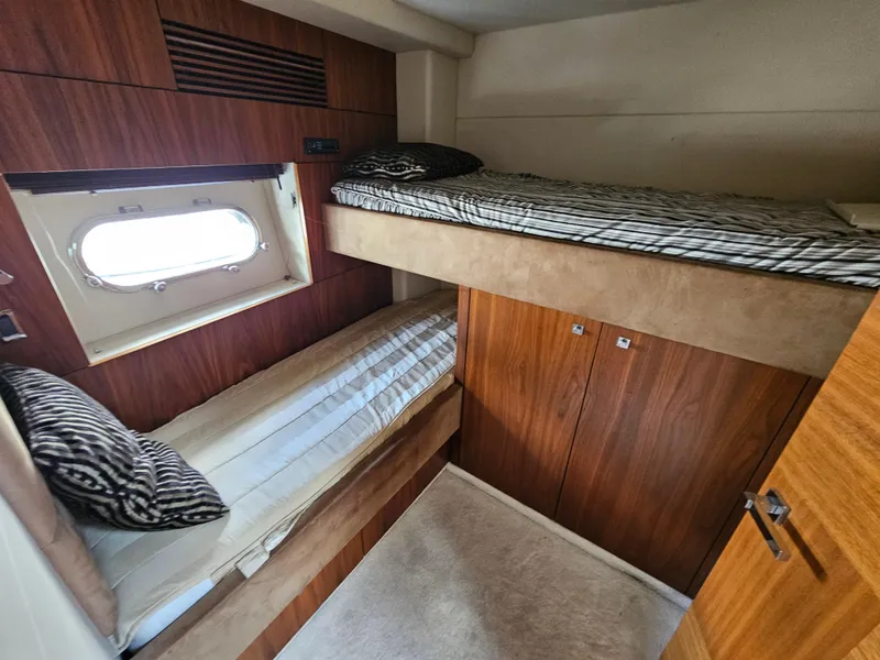Slide: The Image of Sunseeker Predator 64 yacht 2010, cozy twin bunk cabin with window and wood paneling. - 13