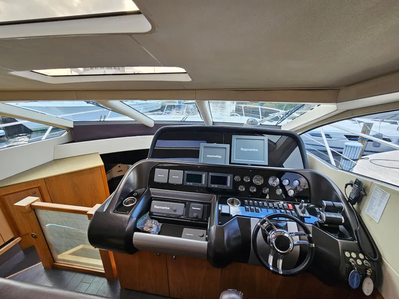 Slide: The Image of Interior helm of 2010 Sunseeker Predator 64 yacht with modern controls and navigation screens. - 7