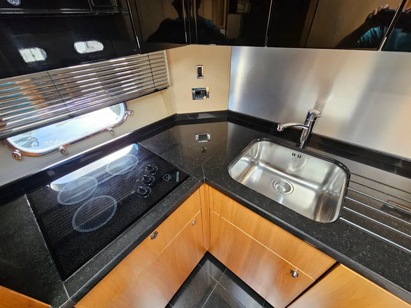 Slide: The Image of Modern kitchen in 2010 Sunseeker Predator 64 yacht with sleek countertops and stainless steel sink. - 9
