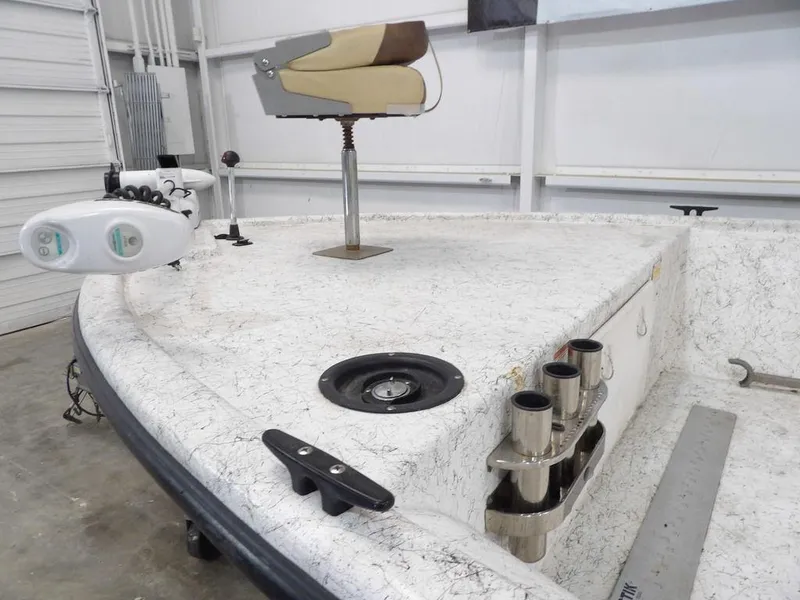 Slide: The Image of 2009 Kenner 180VX boat deck with fishing seat and rod holders in a garage. - 8