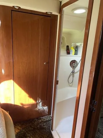 Slide: The Image of 2003 Sea Ray 550 Sundancer bathroom with wooden door and shower area. - 15