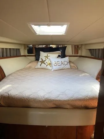 Slide: The Image of Luxurious 2003 Sea Ray 550 Sundancer cabin with cozy bed and beach-themed decor. - 17