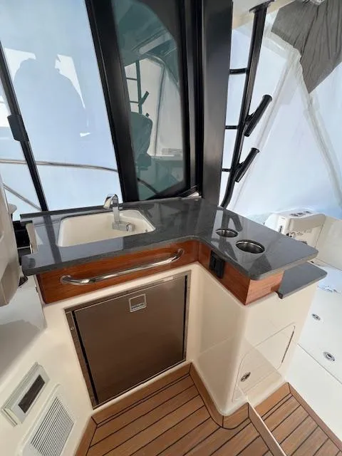Slide: The Image of 2025 Boston Whaler 365 Conquest boat interior with sleek kitchenette and modern design. - 6