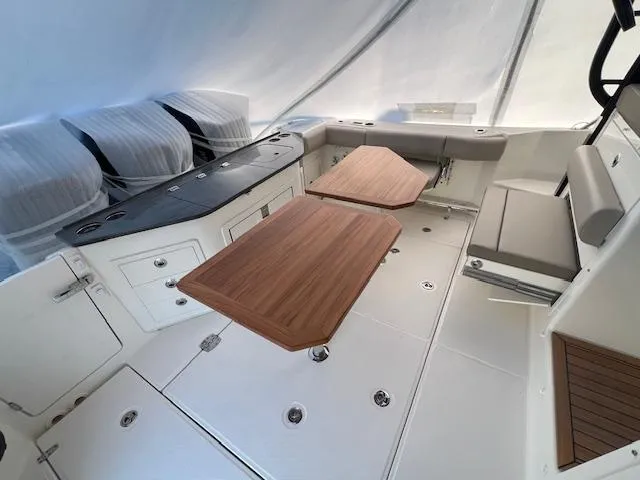 Slide: The Image of 2025 Boston Whaler 365 Conquest interior with wooden tables and seating area. - 8