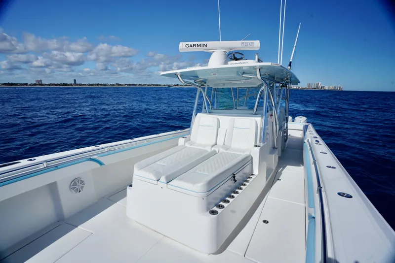 Slide: The Image of 2020 SeaHunter 46 CTS boat on open ocean, clear sky, and distant shoreline. - 14