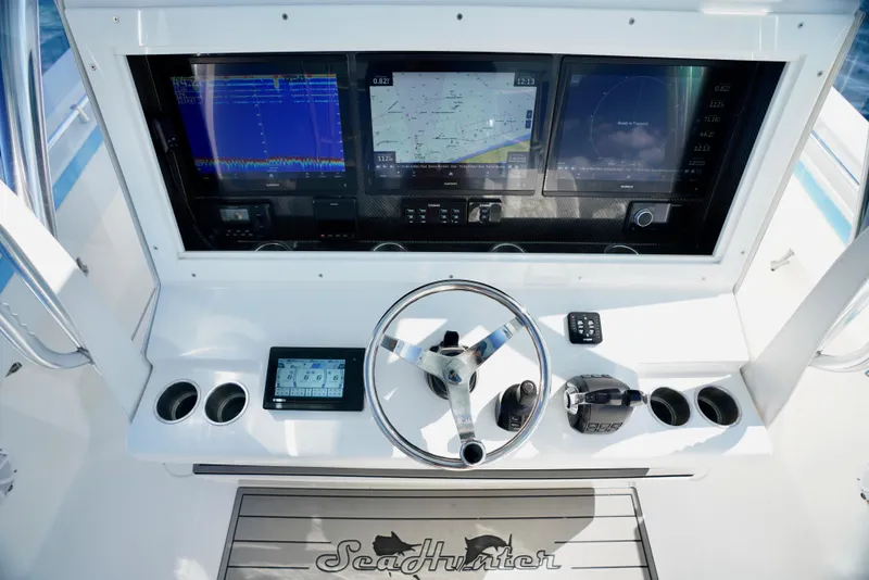 Slide: The Image of 2020 SeaHunter 46 CTS boat dashboard with advanced navigation screens and controls. - 21