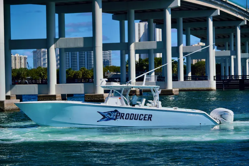 Slide: The Image of 2020 SeaHunter 46 CTS boat cruising under a bridge in a cityscape. - 26