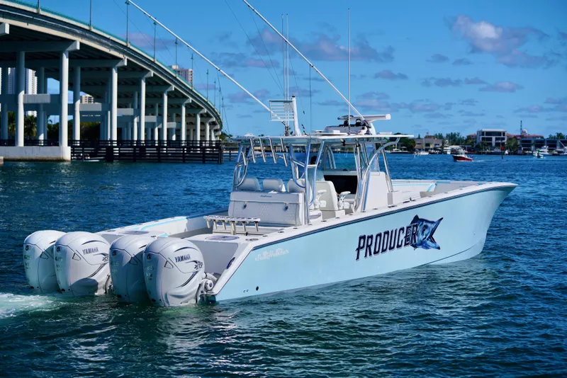 Slide: The Image of 2020 SeaHunter 46 CTS boat with triple Yamaha engines on water near a bridge. - 33